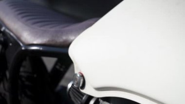 Moda modası geçmiş Cafe Racer motorsikletinin yakın çekim görüntüleri. Motosiklet koltuğu, tekerlek, şok emici yakın çekim görüntüsü.