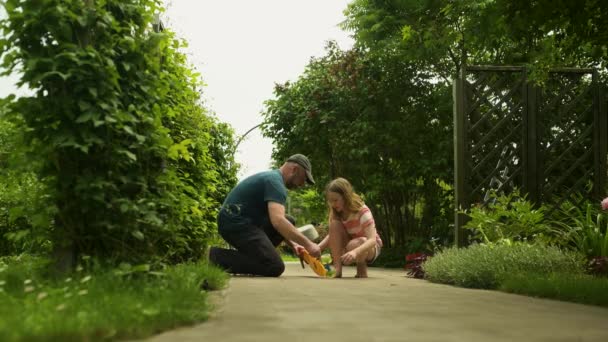 Young Father Fixing Skateboard His Young Daughter Pretty Little Girl — 图库视频影像
