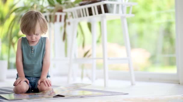 Кадри Милого Хлопчика Який Читає Книжки Підлозі Вдома Денний Догляд — стокове відео