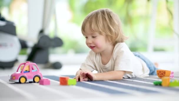可爱的蹒跚学步的男孩在家里的地板上玩乐高积木 日间护理创造性活动 孩子们玩玩具很开心教育学习游戏 家庭室内休闲 — 图库视频影像