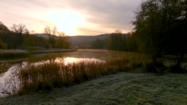 Soğuk, güneşli bir sonbahar sabahı göl manzarası. Sonbaharda güzel sisli orman sahnesi. Rönesans buzu, çim örtüsü, sarı yapraklar. Vilnius, Litvanya 'da sonbahar manzarası