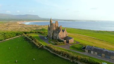 Classiebawn Castle ve Mullaghmore Head 'in muhteşem hava yörüngesi gün batımı manzarası kıyıya vuran büyük dalgalarla birlikte. Hız rampası etkisi. Vahşi Atlantik Yolu 'nun imza noktası, Sligo, İrlanda.