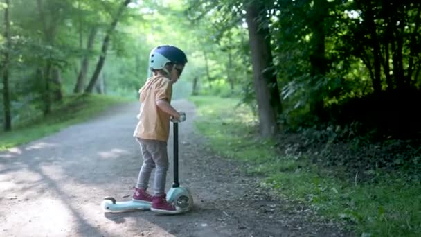 Zabawny Chłopczyk Jeżdżący Dziecięcym Skuterze Świeżym Powietrzu Letni Dzień Równowaga — Wideo stockowe