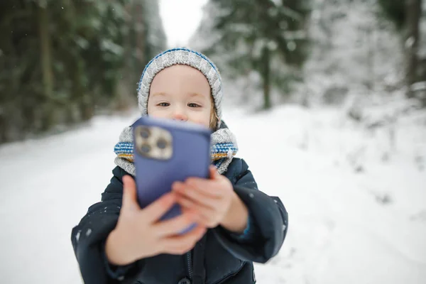 寒い冬の日に雪に覆われた松林の中で散歩を楽しんでいるかわいい幼児の少年 子供は自然を探索する 小さな子供のための冬の活動 — ストック写真