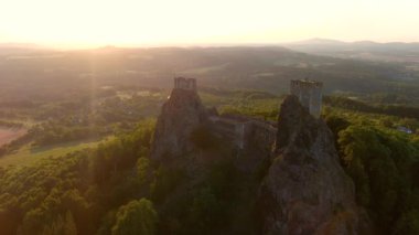 Trosky Castle namı diğer Hrad Trosky hava yörüngesi günbatımı görüntüsü. Ünlü simge, Bohem Cenneti 'nin ana sembollerinden biri. Romantik atmosferi ve eşsiz dış görünüşüyle turizm merkezi popülerdir..
