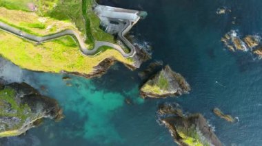 Dunquin veya Dun Chaoin İskelesi, Irelands Koyun Yolu. Dar patikaların yukarıdan aşağıya havadan görünüşü rıhtıma, okyanus kıyısına doğru iniyor. Slea Head Drive ve Wild Atlantic Yolu 'nda popüler ikonik konum.