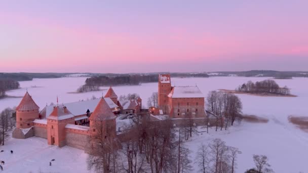 位于立陶宛特拉凯的特拉凯岛城堡的美丽的空中轨道晚景 雪覆在冰封的加尔夫湖上 是冬天戏剧性的落日 立陶宛维尔纽斯附近的冬季风景 — 图库视频影像