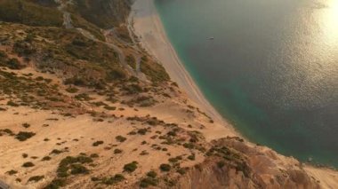 Myrtos plaj, en ünlü ve en güzel plaj Kefalonia, büyük bir sahil tarafından dik kayalıklarla çevrili gezinti su ve beyaz kaba kum ile hava görünümünü. Kefalonia, Yunanistan.