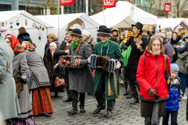 VILNIUS, LITHUANIA - 4 Mart 2023: Kaziuko muge veya Kaziukas, geleneksel Paskalya pazarı sırasında mizahi geçit törenine katılan neşeli insanlar, her Mart ayında Old Town sokaklarında el sanatları fuarı düzenleniyor.