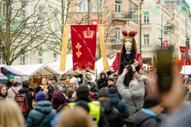 VILNIUS, LITHUANIA - 4 Mart 2023: Kaziuko muge veya Kaziukas, geleneksel Paskalya pazarı sırasında mizahi geçit törenine katılan neşeli insanlar, her Mart ayında Old Town sokaklarında el sanatları fuarı düzenleniyor.