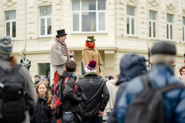 VILNIUS, LITHUANIA - 4 Mart 2023: Kaziuko muge veya Kaziukas, geleneksel Paskalya pazarı sırasında mizahi geçit törenine katılan neşeli insanlar, her Mart ayında Old Town sokaklarında el sanatları fuarı düzenleniyor.