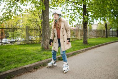 Güneşli bir bahar akşamında güzel bir genç kız mobiletiyle şehirde geziyor. Patenle gezen güzel bir çocuk. Çocuklar için aktif eğlence ve açık hava sporları.