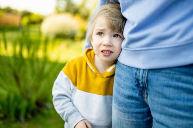 Sevimli komik çocuk annesine sarılıyor. Anne ve oğlu güneşli bir yaz gününde parkta eğleniyorlar. Sevimli oğlu annesi tarafından tutuluyor..