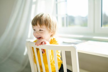 Sevimli çocuk evde eğleniyor demek. Çocuk sıcak bir oturma odasında vakit geçiriyor. Evde aile eğlencesi..
