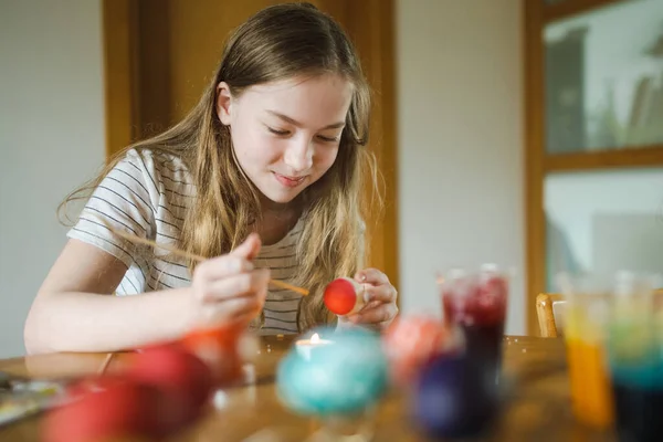 漂亮的少女在家里染色复活节彩蛋 孩子画彩蛋供复活节打猎用 孩子们准备参加复活节庆祝活动 家庭传统 — 图库照片