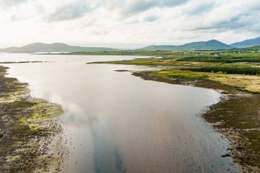 Kerry Çemberi boyunca Derreen Nehri 'nin hava gün batımı manzarası. Gün batımında Iveragh Yarımadası 'nın engebeli kıyıları, Kerry ilçesi, İrlanda.