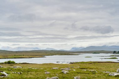 İrlanda 'nın Connemara bölgesindeki Glenicmurrin Lough gölünün güzel manzarası. Ufukta muhteşem dağları olan İrlanda manzarası Galway ilçesi, İrlanda.