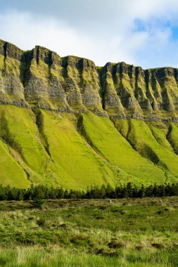 Benbulbin 'in havadan görünüşü, diğer adıyla Benbulben veya Ben Bulben, simgesel simge, büyük düz uçlu nunatak kaya oluşumu. Wild Atlantic Way, County Sligo, İrlanda 'daki muhteşem kostüm sürüş rotası.