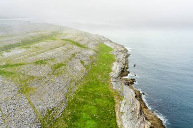 İrlanda 'nın Clare ilçesinin Burren bölgesinde muhteşem sisli hava manzarası. Burren Ulusal Parkı 'nda karst kireç taşına maruz kalmış. Sert İrlanda doğası.