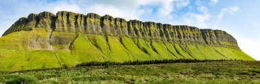 Aerial view of Benbulbin, aka Benbulben or Ben Bulben, iconic landmark, large flat-topped nunatak rock formation. Magnificent costal driving route view at Wild Atlantic Way, County Sligo, Ireland.