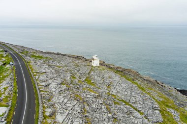 Burren 'in engebeli kayalık arazisinde yer alan Kara Başlı Deniz Feneri dik kireçtaşı dağları ve kayalık kıyı şeridi arasında yer alır..