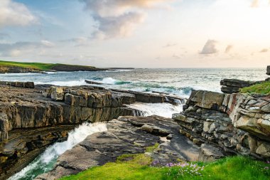 Mullaghmore Head 'in muhteşem gün batımı manzarası. Büyük dalgalar kıyıya vuruyor. Akşam ışığında kayalık kıyı şeridi olan resim gibi bir manzara. Vahşi Atlantik Yolu 'nun imza noktası, Sligo İlçesi, İrlanda