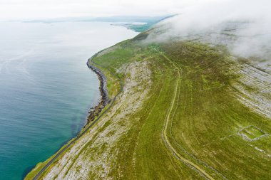 İrlanda 'nın Clare ilçesinin Burren bölgesinde muhteşem sisli hava manzarası. Burren Ulusal Parkı 'nda karst kireç taşına maruz kalmış. Sert İrlanda doğası.