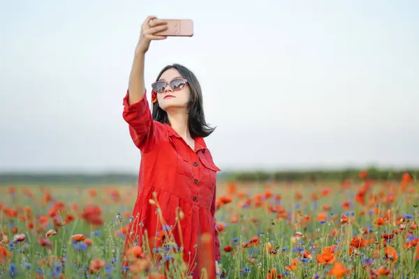 美しい十代の少女は晴れた夏の日にポピーと花を咲かせたポピーを賞賛しています リトアニアのヴィリニュス近くの美しい夏の風景 — ストック写真