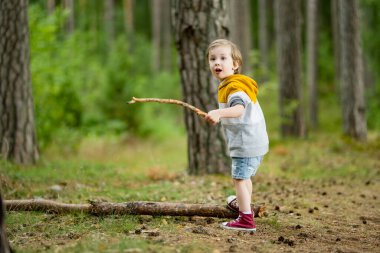Tatlı küçük çocuk güneşli bir yaz gününde dışarıda eğleniyor. Doğayı keşfeden çocuk. Çocuk seyahate çıkıyor. Çocuklu aileler için yaz etkinlikleri.