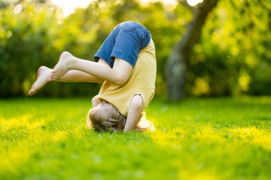 Sevimli küçük çocuk güneşli bir yaz gününde dışarıda eğleniyor. Çocuk dışarıda koşuyor. Doğayı keşfeden çocuk. Küçük çocuklar için yaz etkinlikleri.