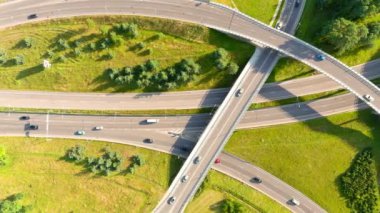 Güneşli yaz gününde trafiğin olduğu üç katlı yol kavşağının yukarıdan aşağı görüntüsü,