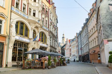 RIGA, LATVIA - 9 AĞUSTOS 2023: Kasaba halkı ve şehir misafirleri Riga 'daki renkli kaldırım taşlı caddelerde geziniyorlar. Letonya 'nın başkentinde canlı bir şehir hayatı.