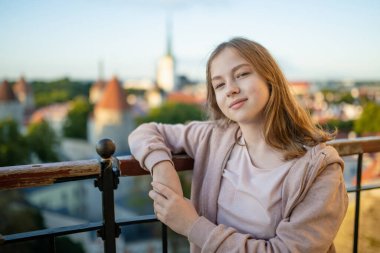 Genç kız güneşli bir yaz sabahında Tallinn Old Town 'ın ikonik gökyüzü manzarasına hayran. UNESCO Dünya Mirası sahası, Estonya.