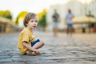Tartu Eski Kasabası 'nın renkli ortaçağ sokaklarında yürüyen sevimli küçük çocuk. 2024 Avrupa Kültür Başkenti. Estonya Şehri 'ni keşfeden çocuk.