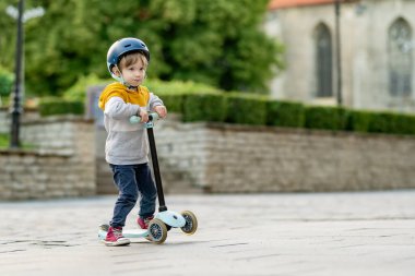 Tallinn Eski Kenti veya Tallinna Valalinn 'in renkli ortaçağ caddelerinde motosikletine binen sevimli küçük çocuk UNESCO Dünya Mirasları Listesi' ne dahil. Estonya başkentini keşfeden çocuk.