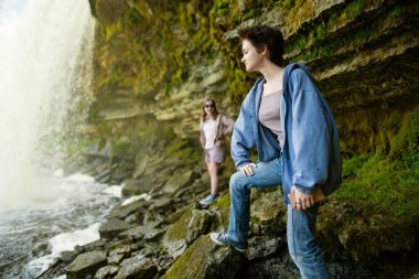 Teenage girls admiring Jagala Waterfall or Jagala juga, the widest natural waterfall in Estonia, located on the Jagala River near the Gulf of Finland. Koogi, Harju County. Northern Estonia. clipart