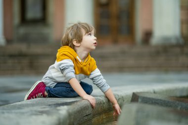 Cute little boy walking along colorful medieval streets of Tallinn Old Town or Tallinna Valalinn, included in the UNESCO World Heritage List. Child exploring Estonian capital.