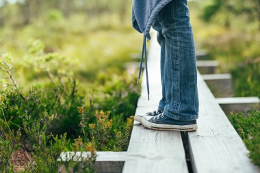 Estonya 'nın Jarva ilçesinde yer alan çam ağaçları, çukurlar ve havuzlarla benekli Seli Bataklığını keşfeden turist. Eşsiz sulak arazi ekosistemi çeşitli vahşi yaşamı destekler ve eşsiz bitki ve hayvanlara ev sahipliği yapar..