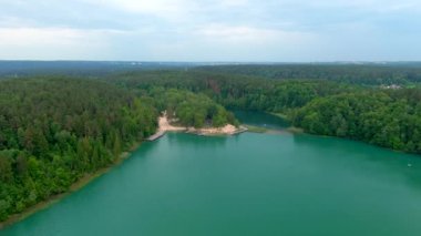 Verkiai Bölgesel Parkı 'ndaki altı Yeşil Gölden biri olan güzel Balsys Gölü' nün hava manzarası. Çam ormanlarıyla çevrili zümrüt göl manzaralı kuş bakışı. Vilnius şehri, Litvanya.