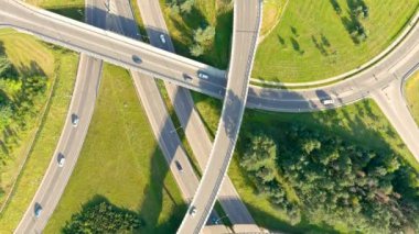 Güneşli yaz gününde trafiğin olduğu üç katlı yol kavşağının yukarıdan aşağı görüntüsü,