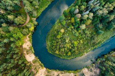 Sventoji nehrinin sonbahar ormanlarında uçuşunu gösteren hava manzarası. Litvanya, Anyksciai yakınlarında güzel bir orman manzarası. Güneşli sonbahar gününde yeşil ağaçlar ve nehir.