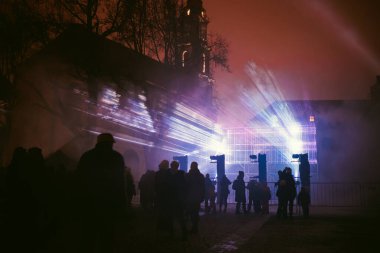 VILNIUS, LITHUANIA - JANUARY 25, 2024: Scenic light installations illuminated by various colors during Vilnius Light Festival in the Old Town of the capital of Lithuania. clipart