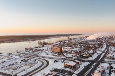 Klaipeda şehrinin liman bölgesinin manzarası ve güneşli bir kış akşamı çevresi. Litvanya 'nın Kadim Klaipeda kasabası, kış vakti akşam vakti.