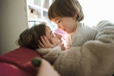 Şirin ablasının küçük kardeşiyle kucaklaşması. Sevimli genç kız kucağında erkek bebek. Geniş yaş farkı olan çocuklar. Kardeşler arasında büyük yaş farkı var..