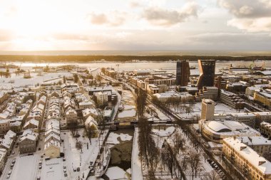 Litvanya 'nın eski Klaipeda kasabasının kışın altın akşam ışığı manzarası. Klaipeda liman bölgesi ve soğuk ve karlı kış günlerinde çevre.