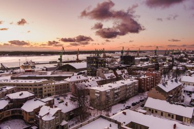 Klaipeda şehrinin liman bölgesinin manzarası ve güneşli bir kış akşamı çevresi. Litvanya 'nın Kadim Klaipeda kasabası, kış vakti akşam vakti.