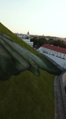 VILNIUS, LITHUANIA - 16 Eylül 2024: duvarların ötesinde. Gediminas Hill 'de Fransız ressam Saype' nin dev duvar resmi. İki sıkışık el, Litvanya ve Fransa arasındaki dostluğu sembolize eder. FPV dikey görünümü.