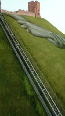 VILNIUS, LITHUANIA - 16 Eylül 2024: duvarların ötesinde. Gediminas Hill 'de Fransız ressam Saype' nin dev duvar resmi. İki sıkışık el, Litvanya ve Fransa arasındaki dostluğu sembolize eder. FPV dikey görünümü.