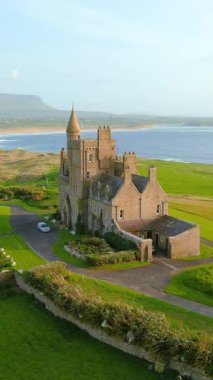 Classiebawn Castle ve Mullaghmore Head 'in muhteşem hava yörüngesi günbatımı görüntüsü ve kıyıya doğru dev dalgalar geliyor. Hız rampası etkisi. Vahşi Atlantik Yolu 'nun imza noktası, Sligo, İrlanda.