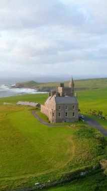 Mullaghmore Head 'in muhteşem hava yörüngesi günbatımı manzarası ve kıyıya vuran büyük dalgalar. Muhteşem Classiebawn Kalesi 'nin olduğu resim gibi bir manzara. Wild Atlantic Way, Co. Sligo, İrlanda 'nın imza noktası